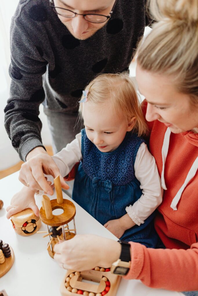 A family enjoys playing with educational wooden toys together indoors.