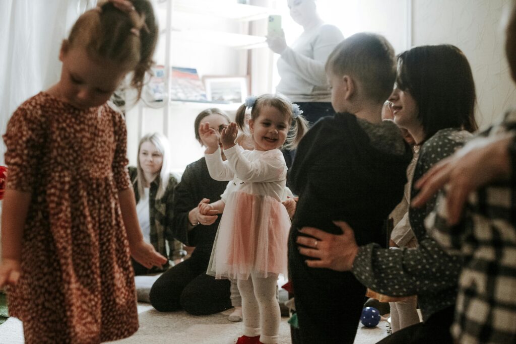 Happy children playing with family and friends during an indoor playdate, full of laughter and joy.